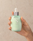 Model holding Alfaparf Milano Semi Di Lino Scalp Calming Tonic 125ml