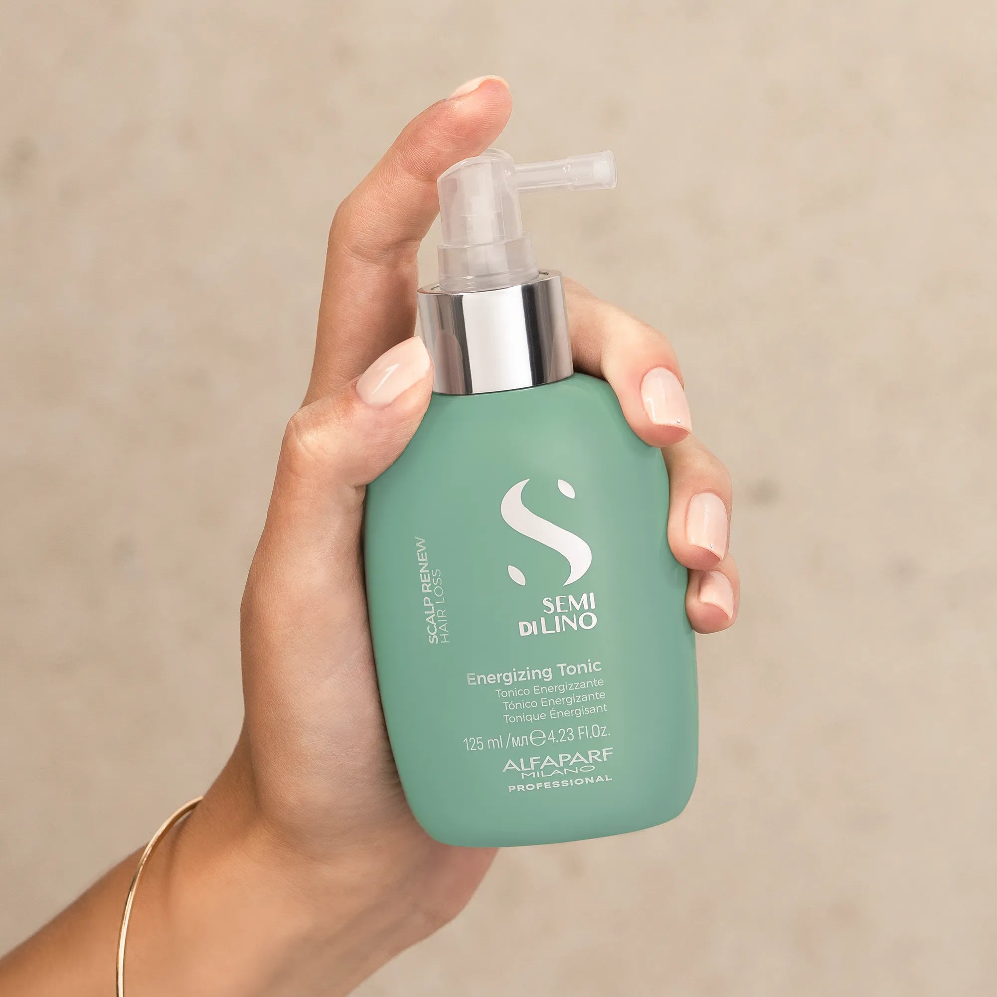 Model holding ALFAPARF MILANO Semi Di Lino Scalp Energising Tonic