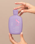 Model holding Alfaparf Milano Semi Di Lino Smooth Smoothing Low Shampoo