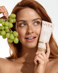Model holding Vita Liberata Original Body Blur, with organic ingredients