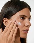 Model applying Vita Liberata The HA+ Face Tan With Niacinamide to her face