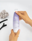 Model holding Beauty Works Anti Yellow Shampoo