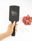 Model holding Beauty Works Large Paddle Brush