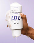 Model holding Color Wow Hooked 100% Clean Shampoo with Root-Locking Technology