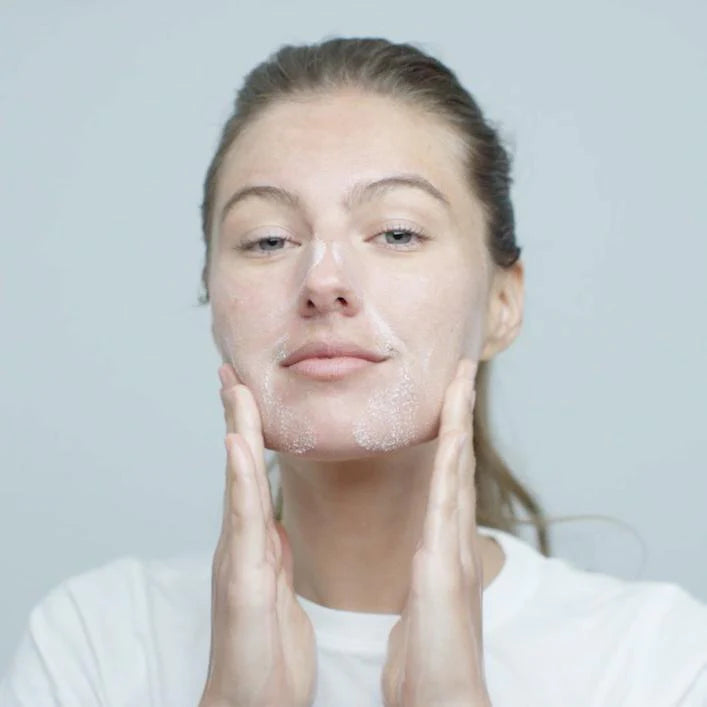 Model applying Dermalogica Precleanse Cleansing Oil to face