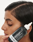 Model holding The Inkey List Salicylic Acid Exfoliating Scalp Treatment