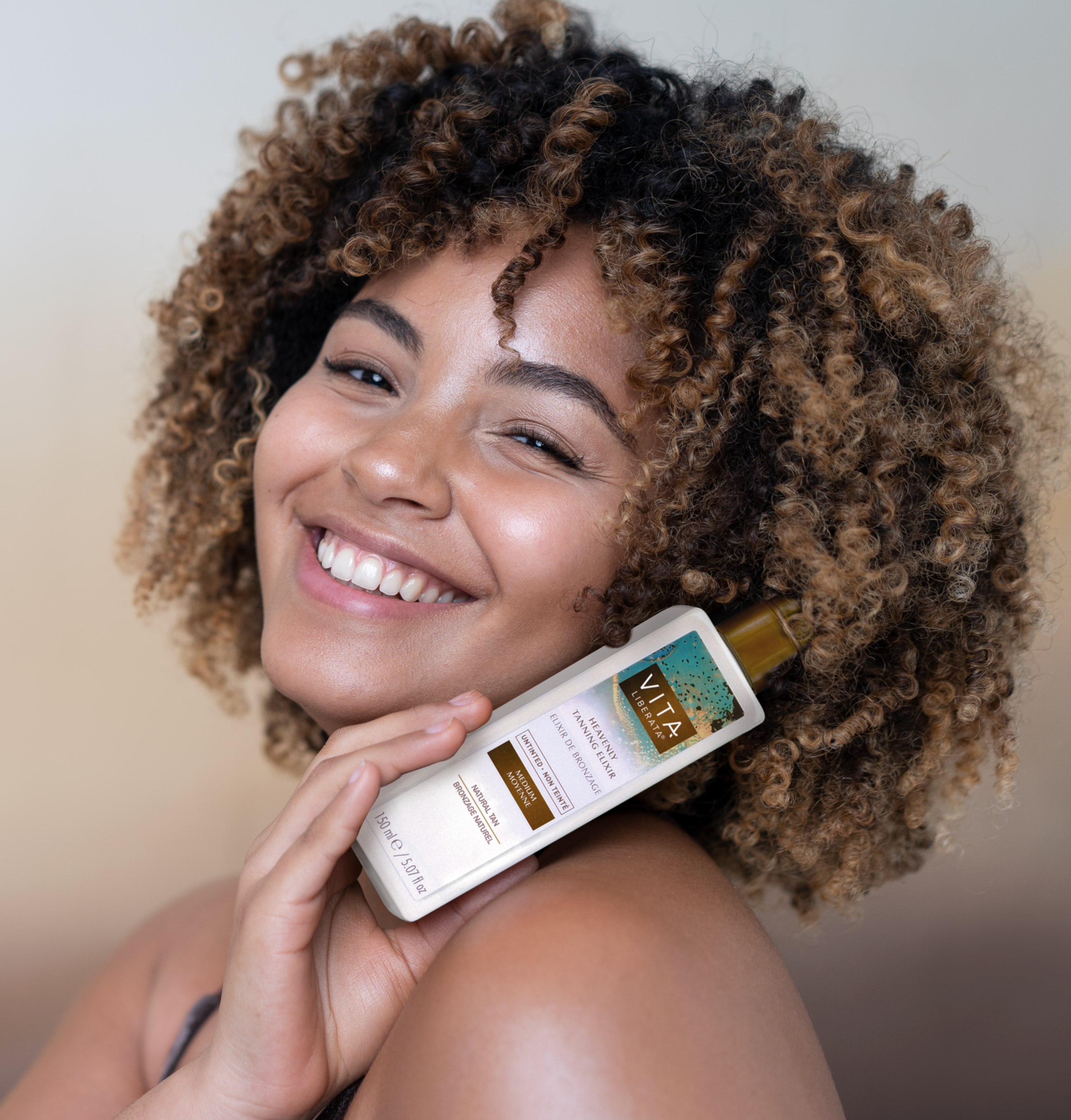 Model holding Vita Liberata Untinted Heavenly Tanning Elixir - Medium