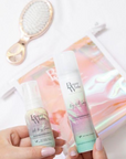 Model holding Beauty Works Dry Oil x Anti Frizz Serum Travel Set