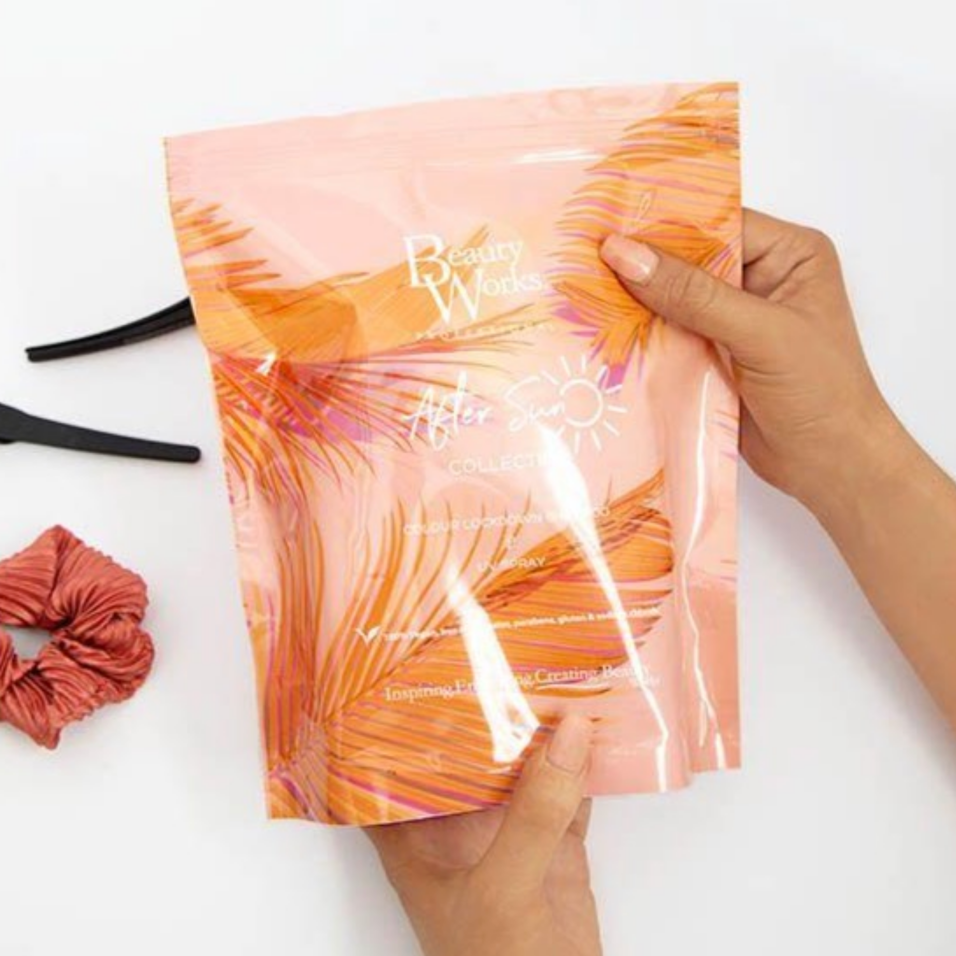 Model holding Beauty Works After Sun Anti-Colour Fade Duo