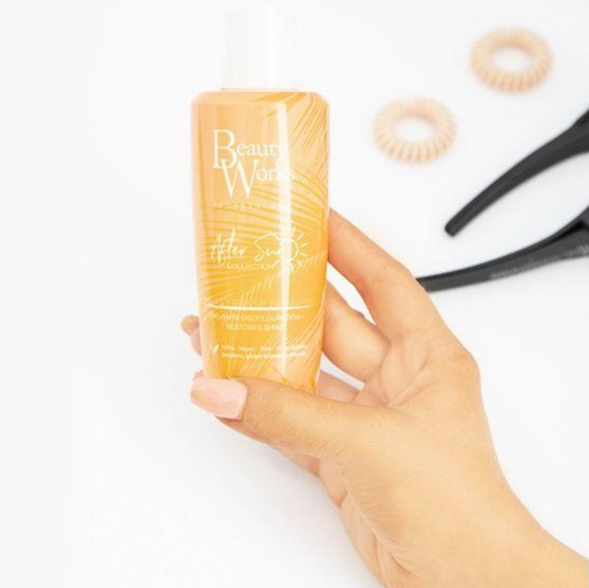 Model holding Beauty Works After Sun Deep Cleanse Shampoo