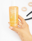 Model holding Beauty Works After Sun Deep Cleanse Shampoo