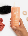 Model holding Beauty Works After Sun Colour Lockdown Shampoo
