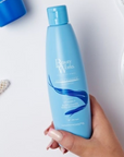 Model holding Beauty Works Anti Orange Shampoo