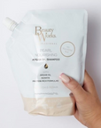 Model holding Beauty Works Pearl Nourishing Shampoo Refill Pouch (Sulfate Free)