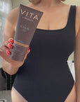 Model holding Vita Liberata The Lotion 