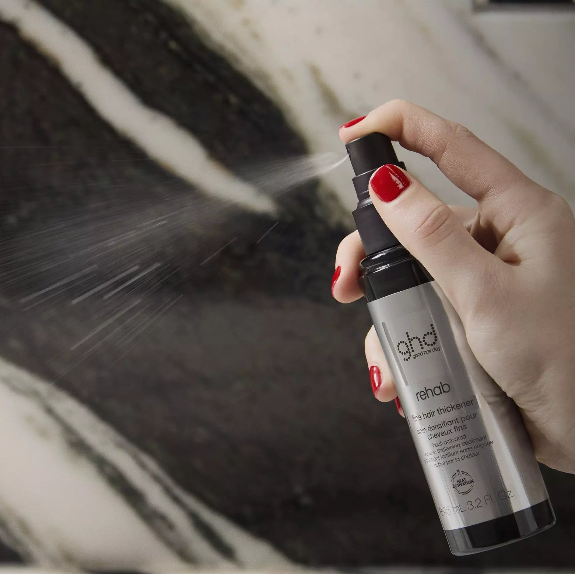 Model holding ghd Rehab Fine Hair Thickener Spray 95ml