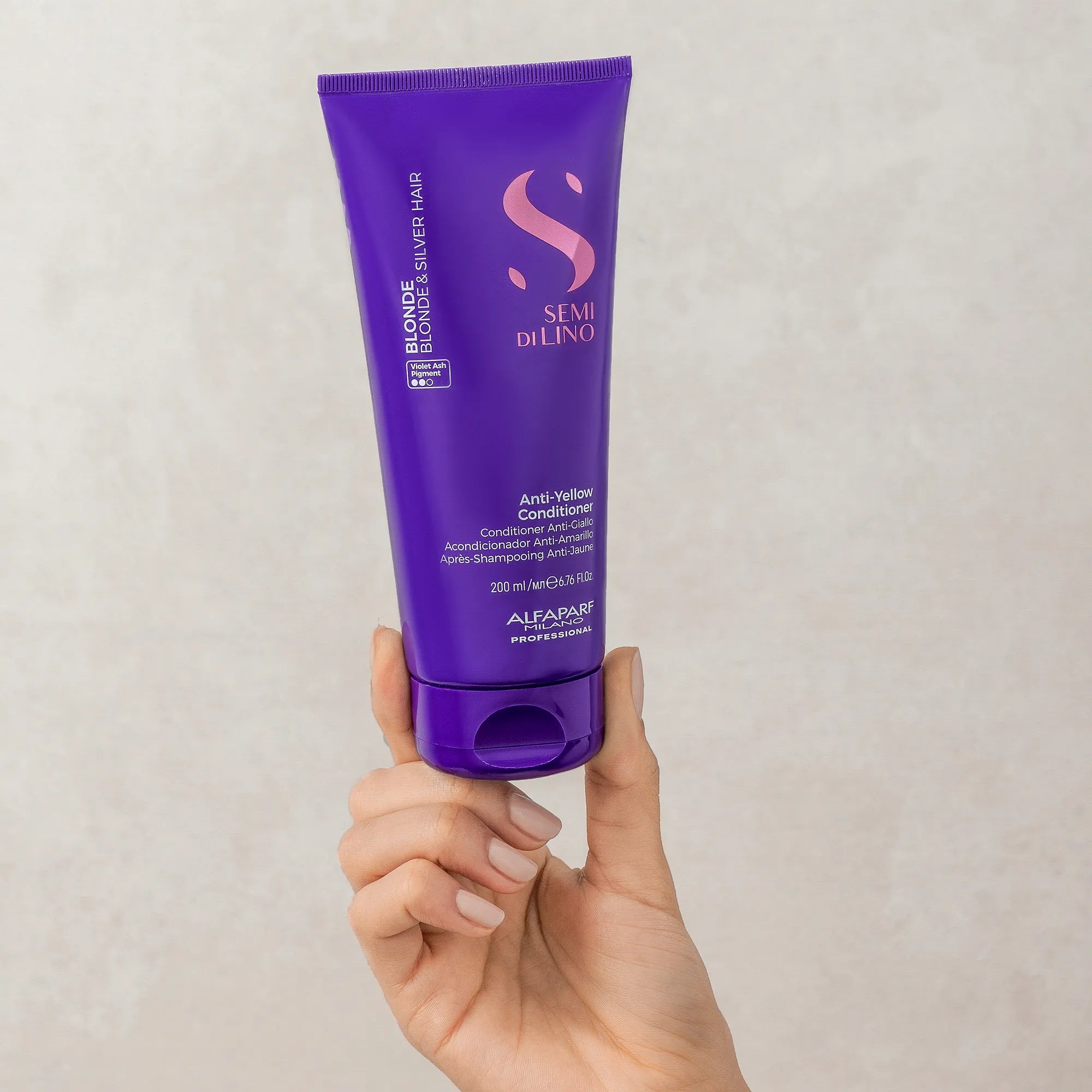 Model holding Alfaparf Milano Semi Di Lino Blonde Anti-Yellow Conditioner