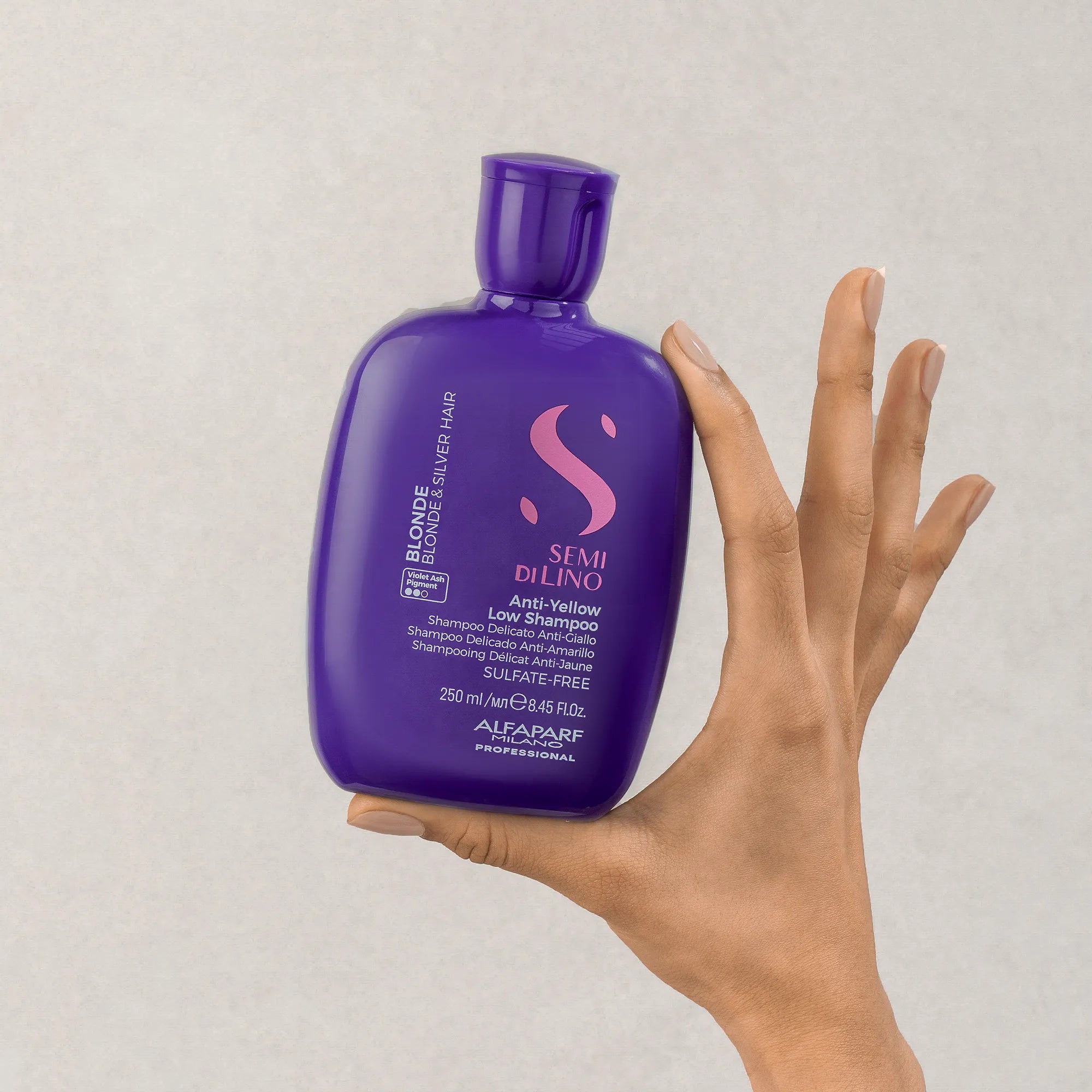 Model holding Alfaparf Milano Semi Di Lino Blonde Anti-Yellow Shampoo