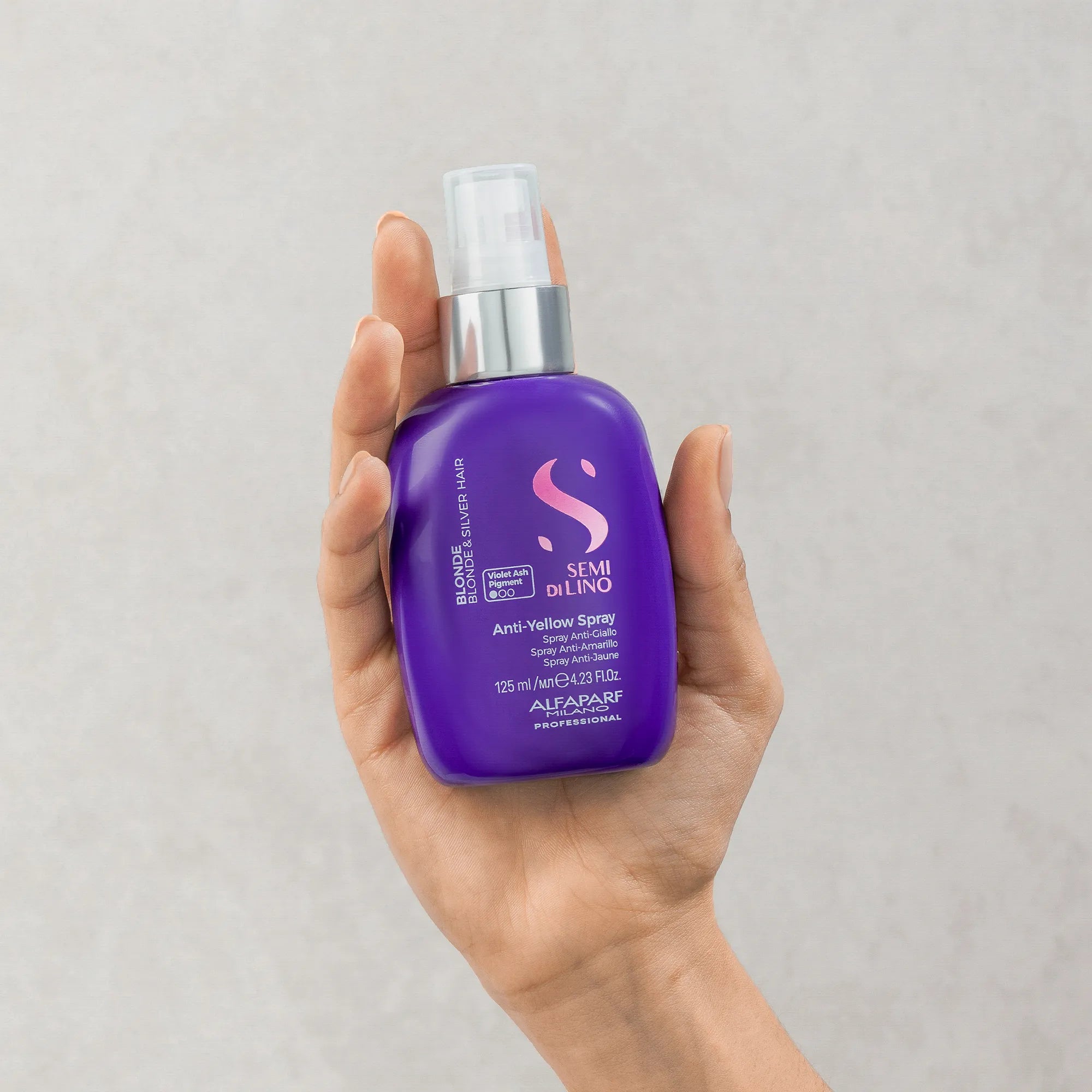 Model holding Alfaparf Milano Semi Di Lino Blonde Anti-Yellow Spray 