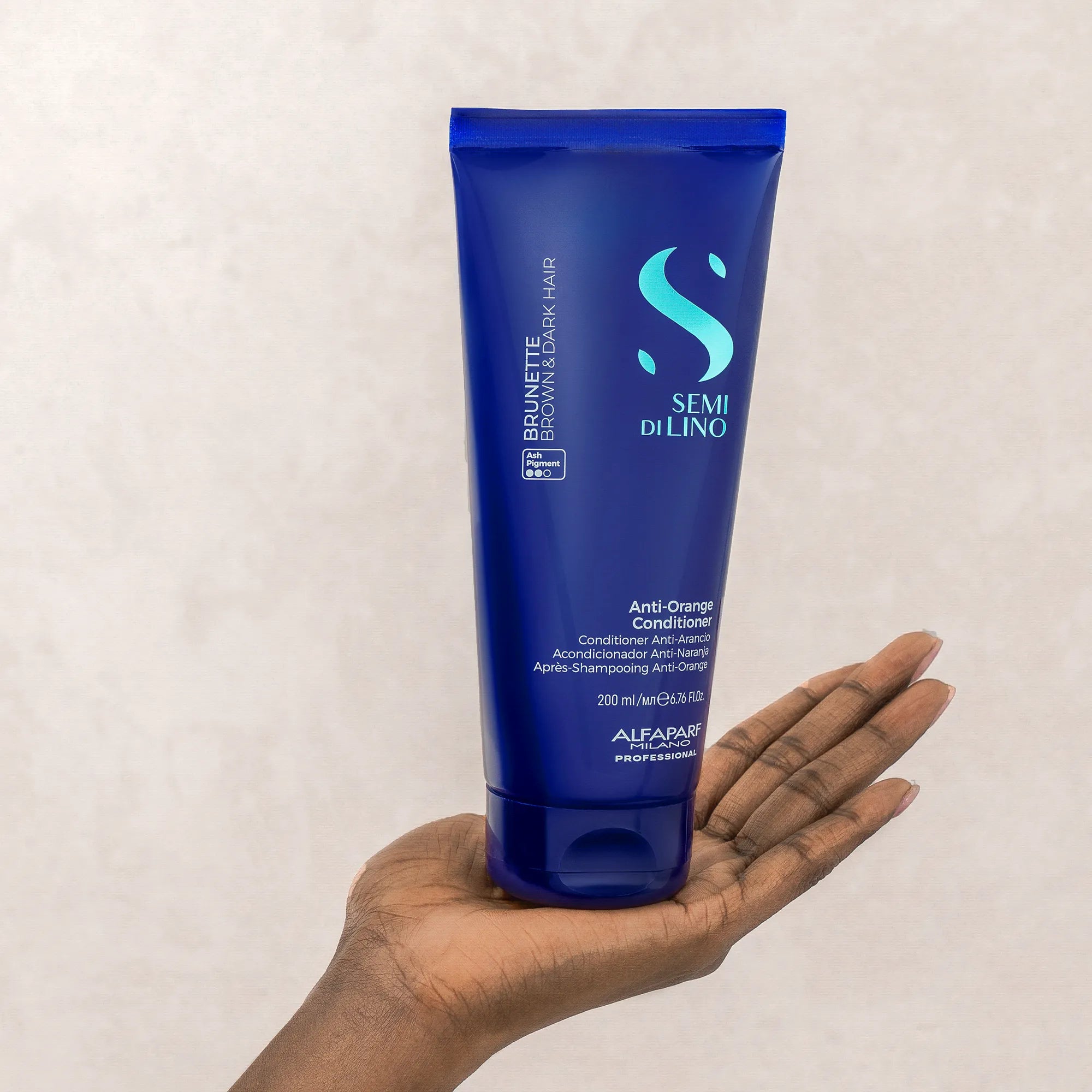 Model holding Alfaparf Milano Semi Di Lino Brunette Anti-Orange Conditioner