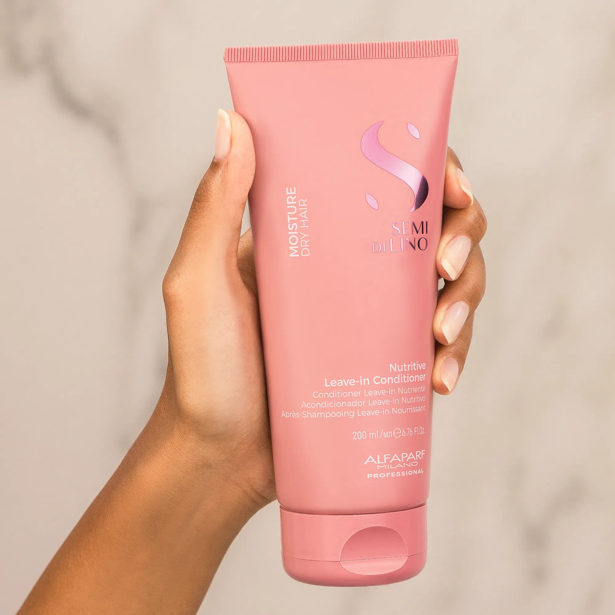 Model holding Alfaparf Milano Semi Di Lino Moisture Nutritive Leave-In Conditioner 