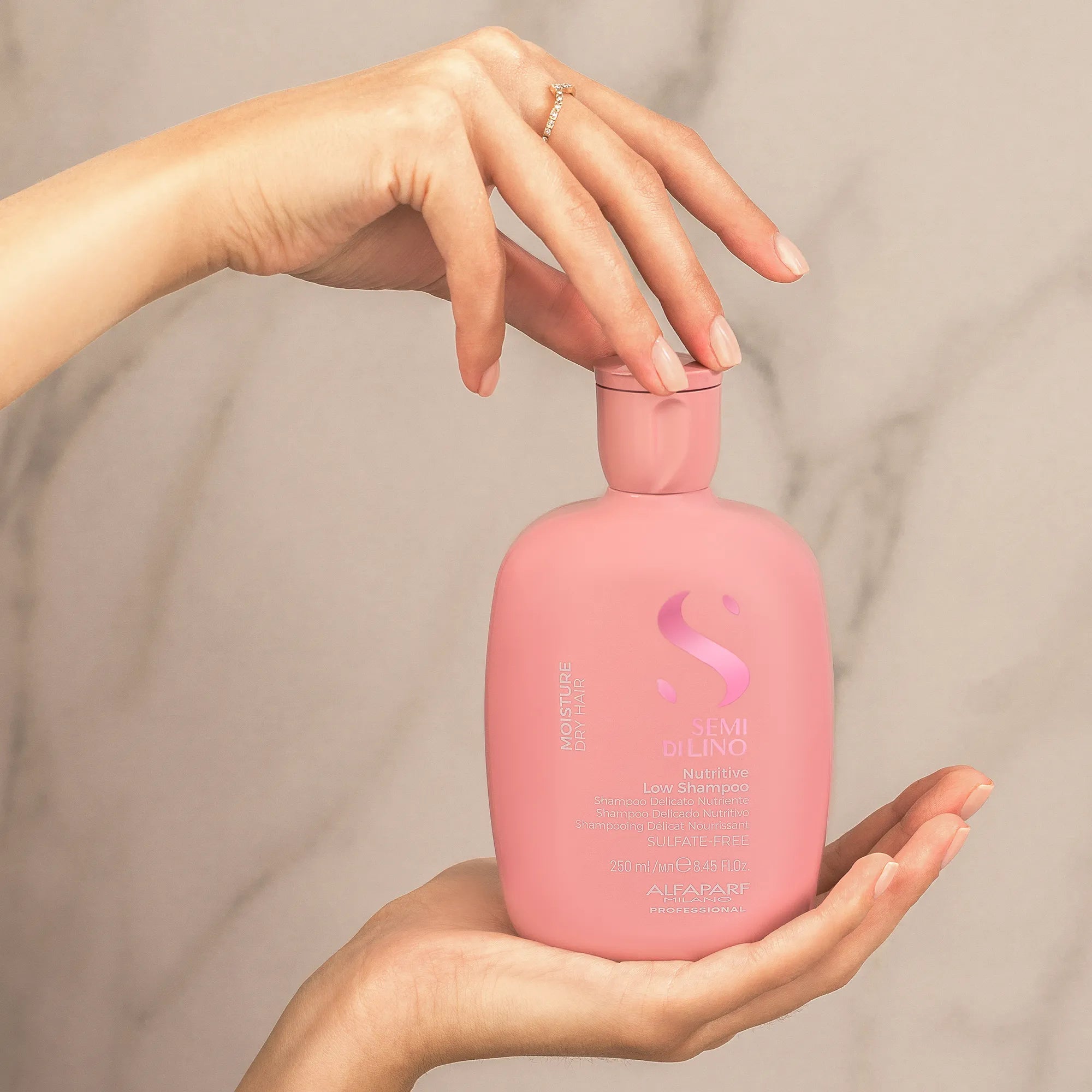 Model holding Alfaparf Milano Semi Di Lino Moisture Nutritive Low Shampoo