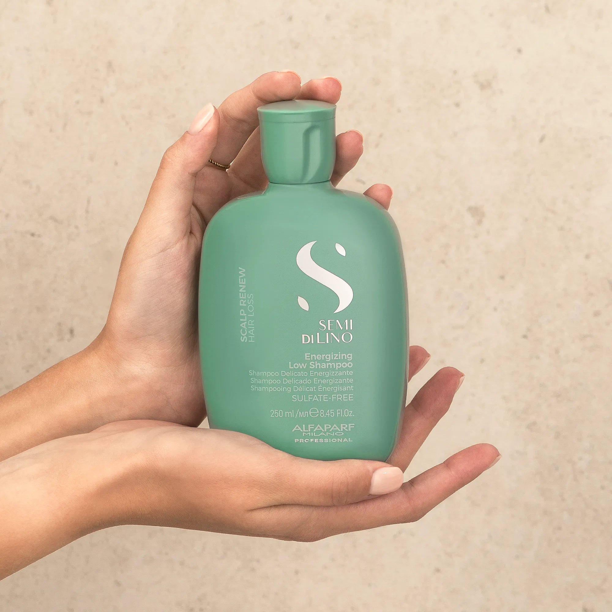 Model holding Alfaparf Milano Semi Di Lino Scalp Renew Energising shampoo