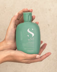 Model holding Alfaparf Milano Semi Di Lino Scalp Renew Energising shampoo