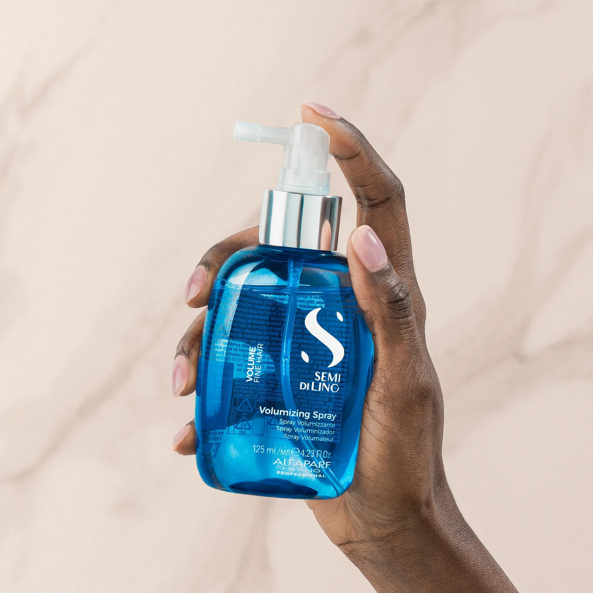 Model holding Alfaparf Milano Semi Di Lino Volume Volumizing Spray 