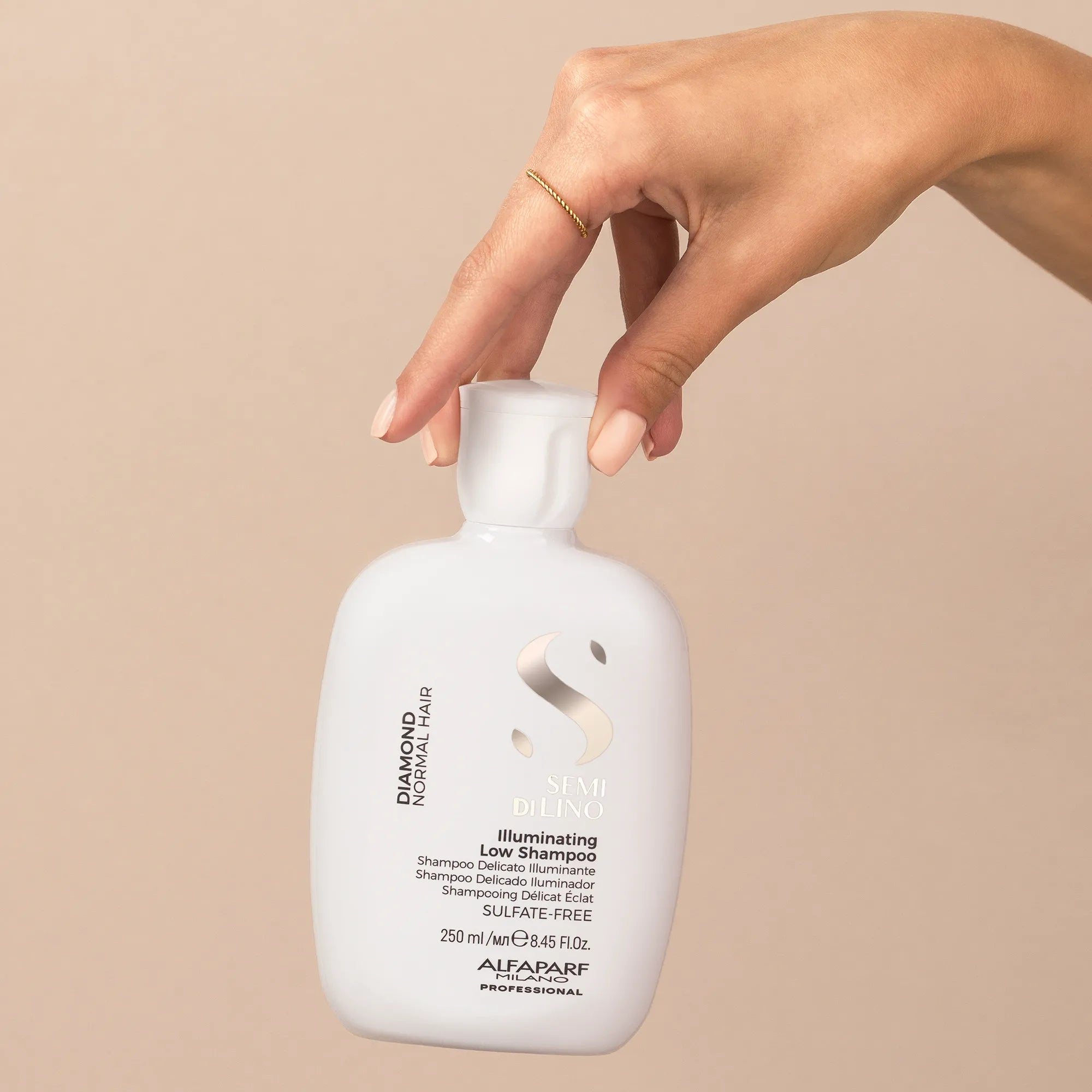 Model holding Alfaparf Milano Semi Di Lino Diamond Illuminating Low Shampoo