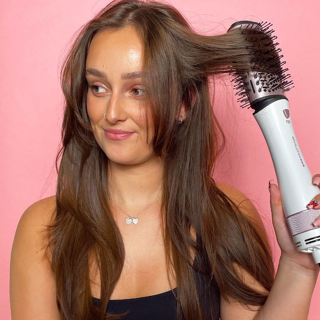 Model holding Revolution Haircare Smooth Boost Hot Air Brush