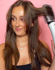 Model holding Revolution Haircare Smooth Boost Hot Air Brush