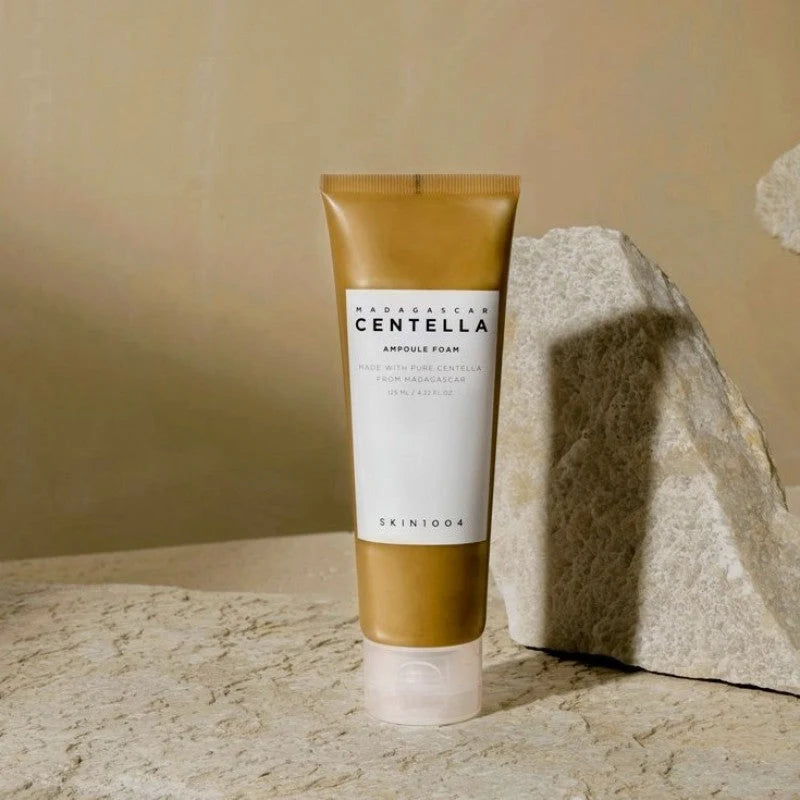 Skin1004 Centella Ampoule Foam sitting beside a stone