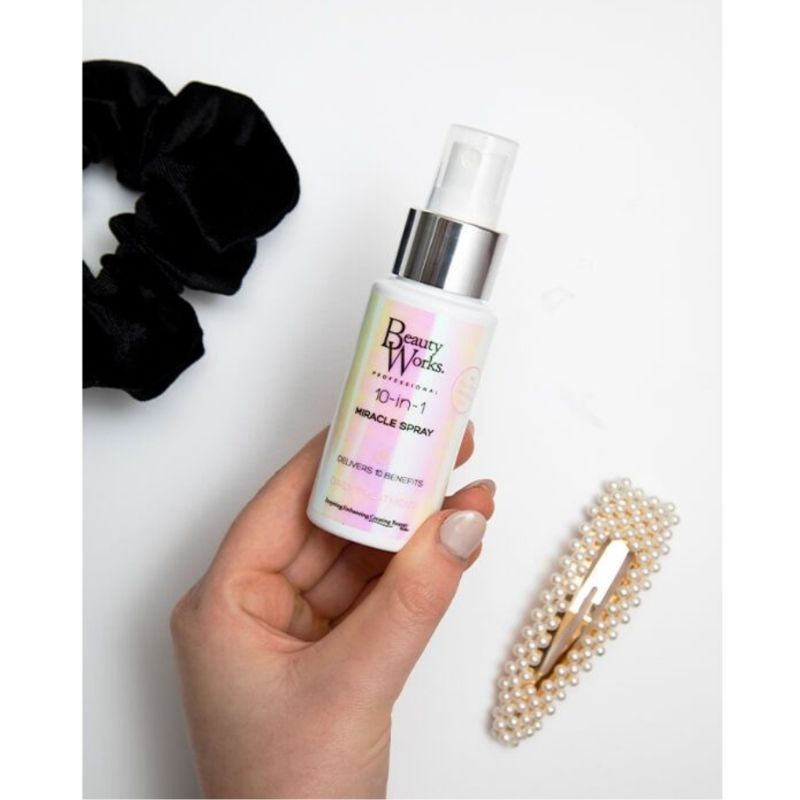Model holding BEAUTY WORKS 10-in-1 Miracle Spray