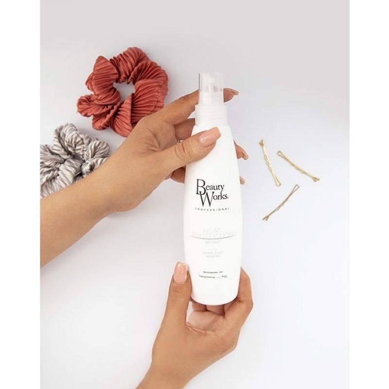Model holding Beauty Works Heat Protection Spray
