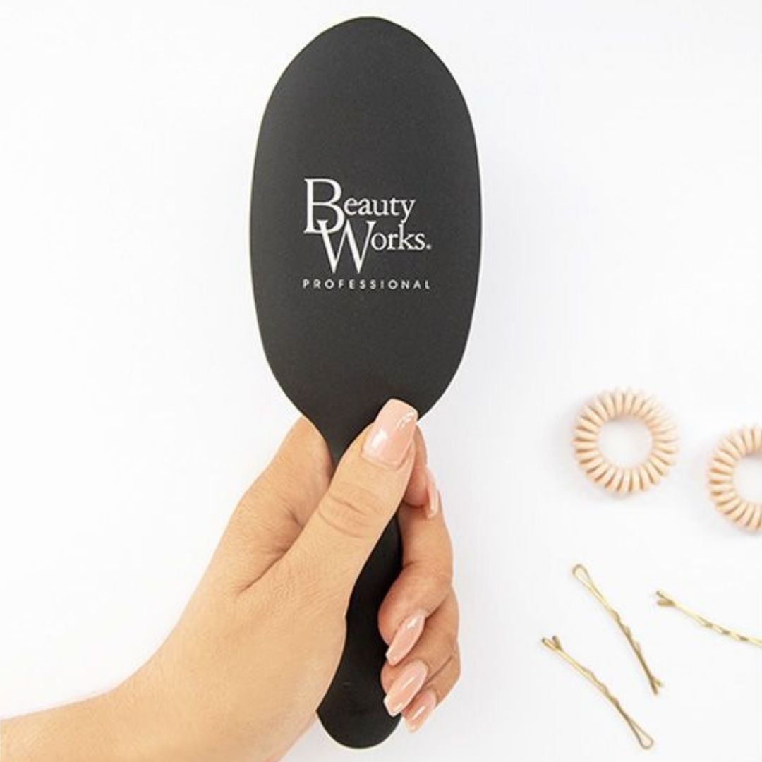 Model holding Beauty Works Medium Oval Brush