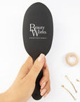 Model holding Beauty Works Medium Oval Brush