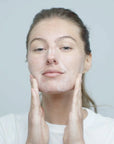 Model applying Dermalogica Precleanse Cleansing Oil to face