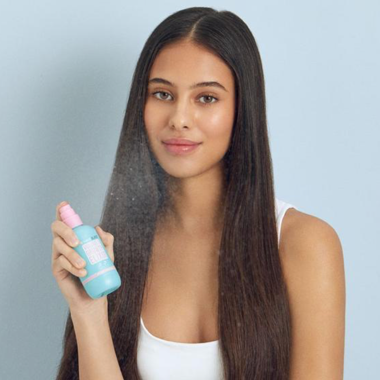 Model holding HAIRBURST Volume & Growth Elixir