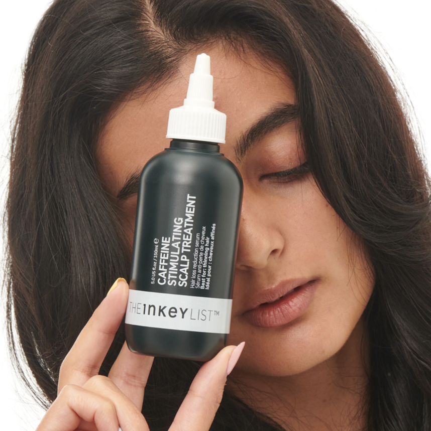 Model holding The INKEY List Caffeine Stimulating Scalp Treatment