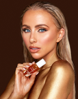 Rosie Connolly holding Inglot Rosie For Inglot Glowing Veil Tanning Oil