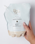 Model holding Beauty Works Pearl Nourishing Shampoo Refill Pouch