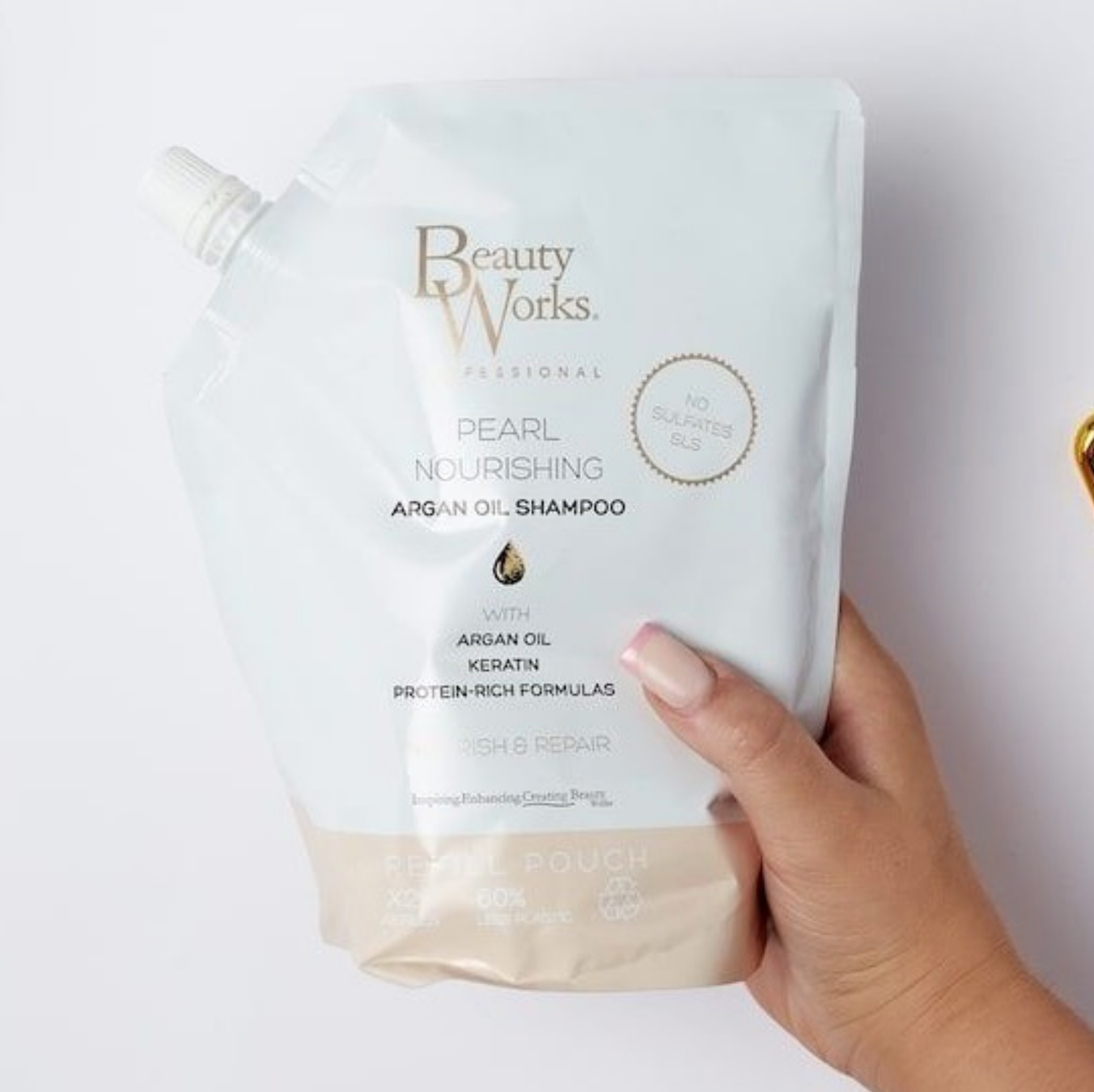 Model holding Beauty Works Pearl Nourishing Shampoo Refill Pouch (Sulfate Free)