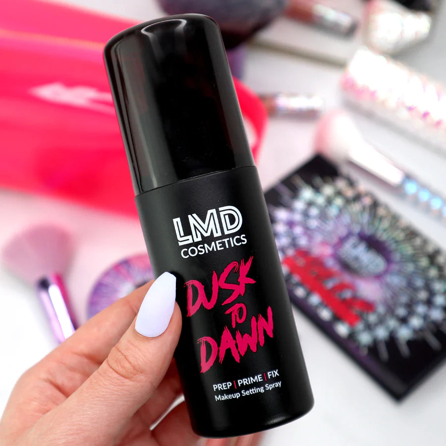 Model holding LMD Cosmetics Dusk To Dawn setting spray